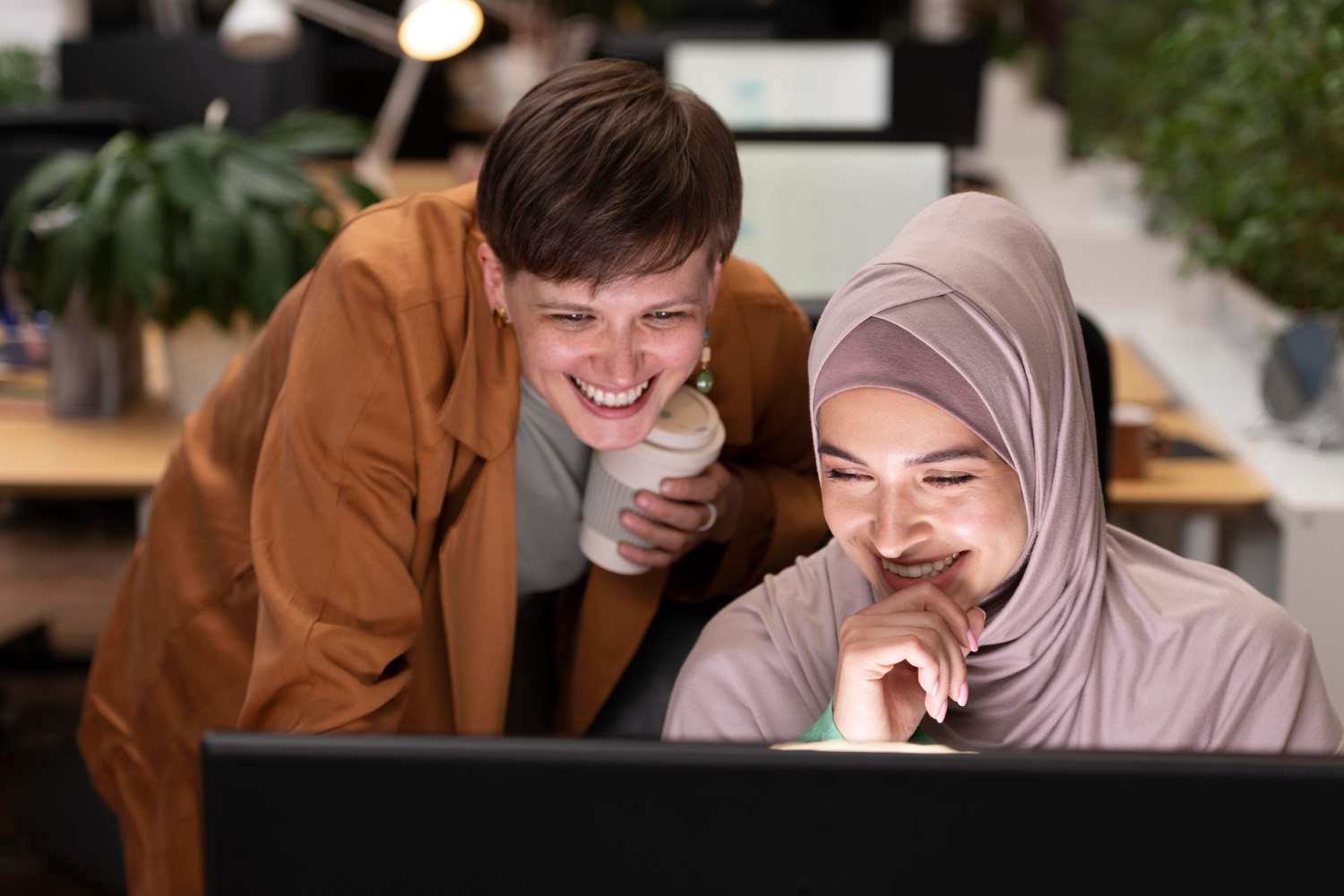 Deux formatrices souriantes devant un écran